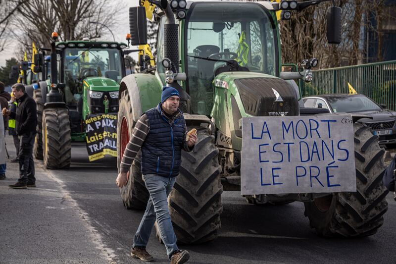 A tractor of a farmer displays a poster reading 'Death is on the meadow' as they make their way along a freeway towards Paris CDG airport, on Saturday. Photograph: Christophe Petit Tesson/EPA