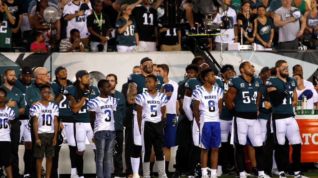 Members of the Philadelphia Eagles stand for the national anthem before they’re NFL meeting with Atlanta Falcons. Photo: Mike Segar/Reuters