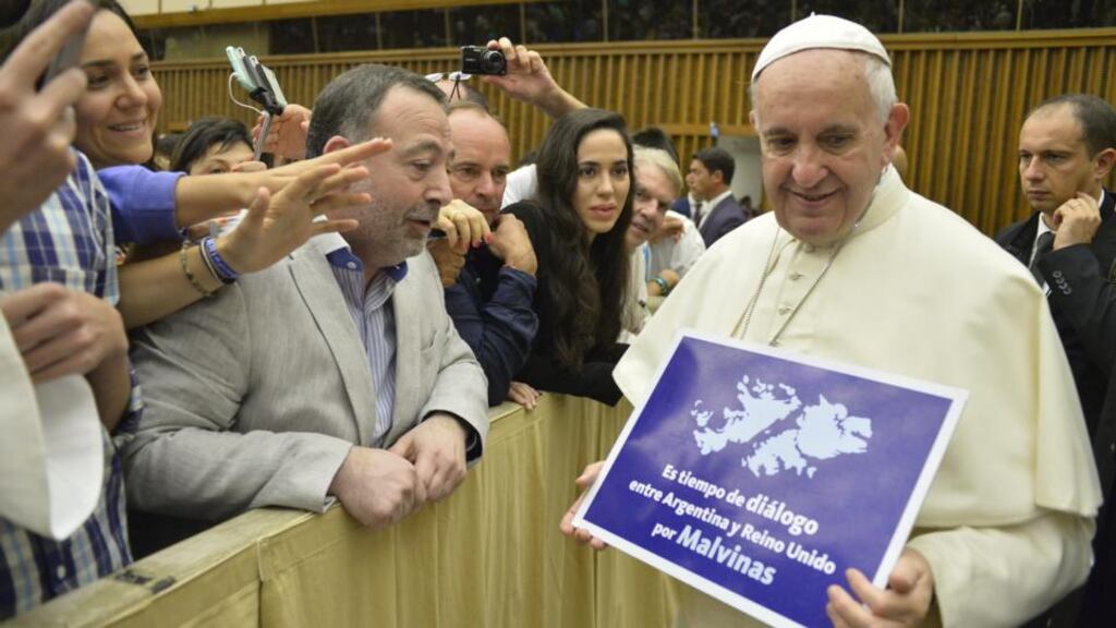Pope Francis holds a placard reading: ‘It’s time for dialogue between Argentina and the United Kingdom for Falklands.’ A spokesman said: ‘The Holy Father did not even realise he had this object in his hands.’ Photograph: L’Osservatore Romano/Pool Photo via AP
