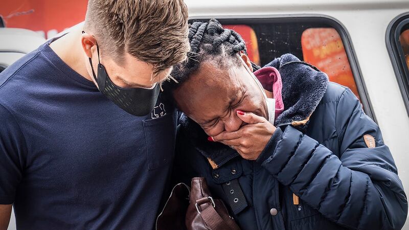 A woman is comforted outside the historical home of Archbishop Desmond Tutu, in Soweto, Johannesburg. Photograph: Shiraaz Mohamed/AP Photo
