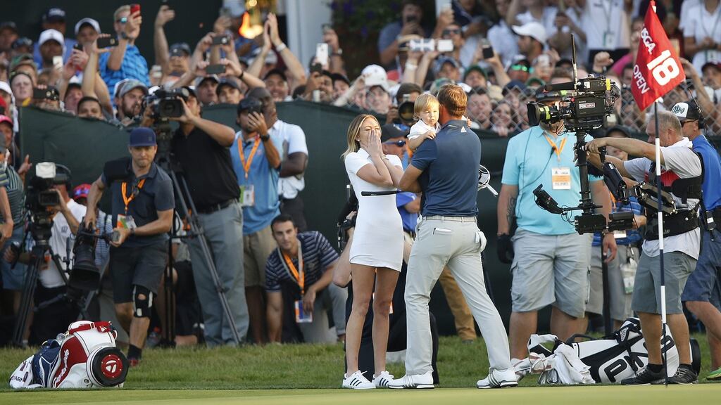 Dustin Johnson holds his son Tatum as his wife Paulina reacts after he birdied the final hole to win the 116th US Open Championship at Oakmont Country Club in Oakmont, Pennsylvania. Photo: Michael Reynolds/EPA