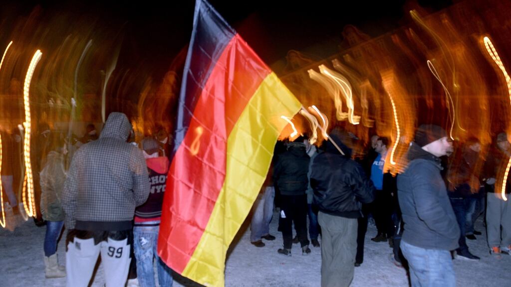 Pegida demonstrators walk with a German flag during a demonstration in Potsdam last month. Anti-racism campaigners and migrant support groups are to hold a rally in Dublin on Saturday to protest against the establishment of an Irish branch of the anti-Islamic group Pegida. Photograph: Ralf Hirschberger/EPA.