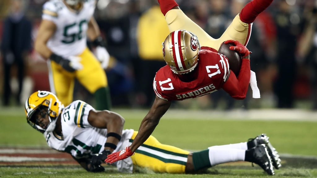 Wide receiver Emmanuel Sanders of the San Francisco 49ers is upended by strong safety Adrian Amos of the Green Bay Packers. Photo: Ezra Shaw/Getty Images