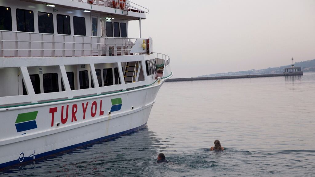 Activists swim as they try to interfere the deportation of migrants on board a ferry set to sail for Turkey in the port of Mytilini on the Greek island of Lesbos. Photograph: Petros Giannakouris/AP