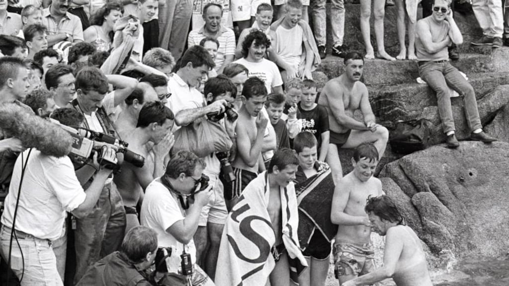 A woman is undeterred by a large spectators’ gallery as she leaves the water after a protest swim at the Forty Foot, the traditional men’s bathing place, in Sandycove, Co Dublin. Photograph: Matt Kavanagh/The Irish Times