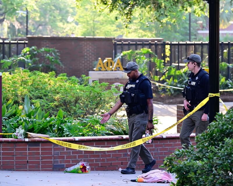 Police officers walk past flowers left at the scene after a gunman shot multiple people at Florida State University in Tallahassee, Florida. Photograph: EPA