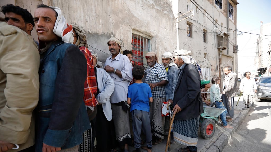 Yemenis wait to get their families’ food aid for Iftar, the meal traditionally taken after sunset prayers to break the Ramadan daily fast, during the Muslim fasting month of Ramadan, at a charitable kitchen in Sana’a. Photograph: Yahya Arhab/EPA