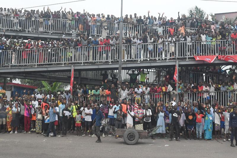 People on the side of the road wave as Pope Francis departs the N'djili International Airport in Kinshasha. Photograph: Tiziana Fabi/AFP via Getty