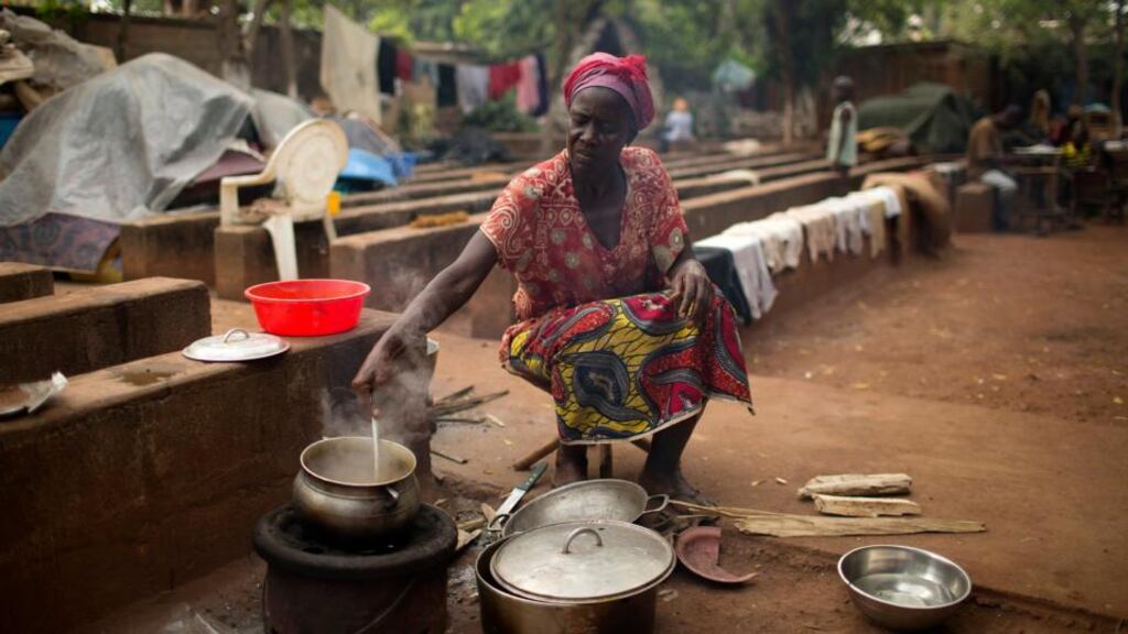 Kapiri Agnes (53) prepares a meal on the grounds of a church that is sheltering about 4,000 internally displaced people fleeing sectarian violence in Bangui. Central Africans say Christians and Muslims lived in harmony until last year. Photograph: Siegfried Modola/Reuters