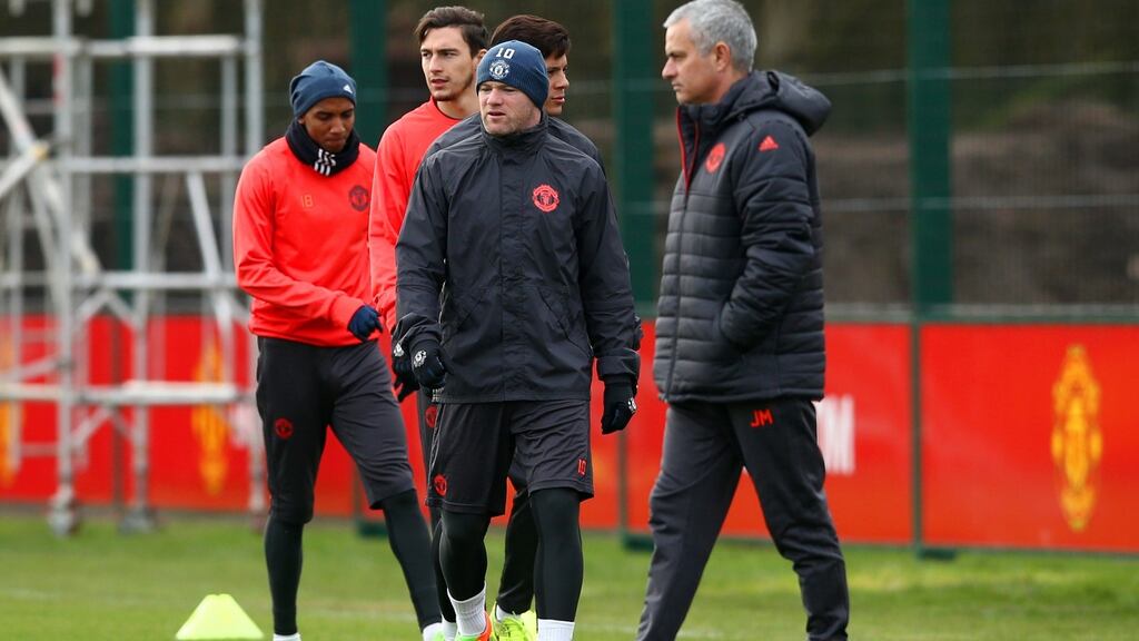 Jose Mourinho walks past Wayne Rooney during a Manchester United training session ahead of the Europa League round-of-32 second leg against St Etienne. Photograph: Jan Kruger/Getty Images