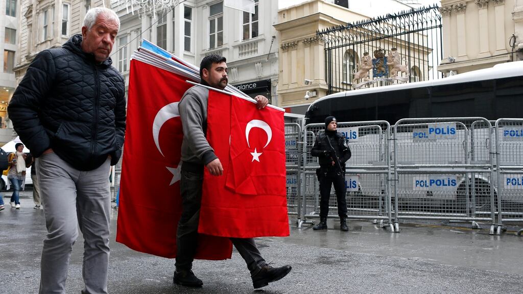 A man carrying Turkish flags walks past a Turkish armed riot policeman in front of the Dutch Consulate in Istanbul, Turkey,  March 13th, 2017. Photograph: Sedat Suna/EPA