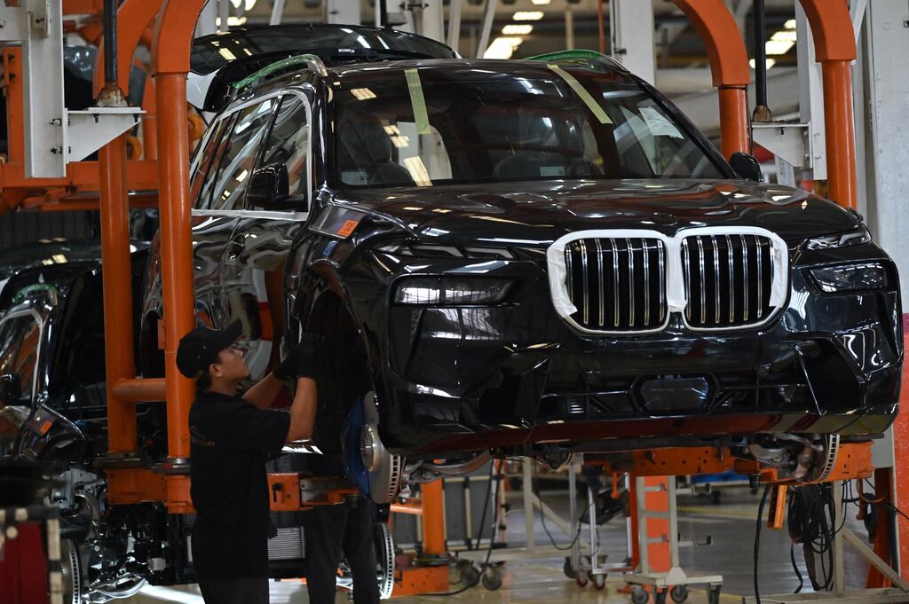 Mechanics at work on a BMW car: the German automaker's shares fell on Friday after analysts downplayed its industry. Photograph by Adek Berry / AFP.