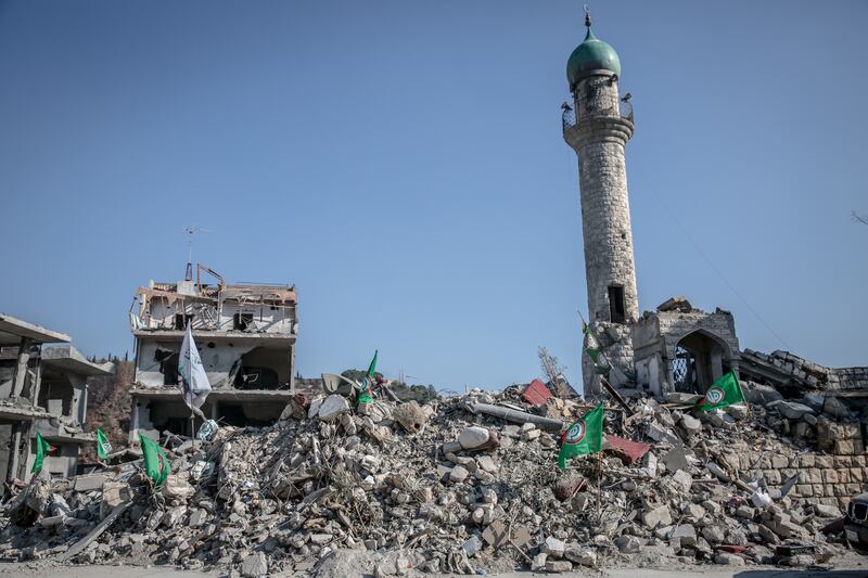The remains of the town square in Kherbet Selem, where a minaret from the mosque is the only part of the centre left standing, and the flag of the Hizbullah-aligned Amal Movement is planted in the rubble. Photograph: Sally Hayden