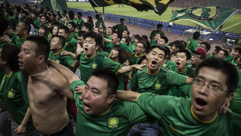 Beijing Guoan: ultra supporters celebrate a goal against Chongcing Lifan in the Chinese Super League. Photograph: Kevin Frayer/Getty
