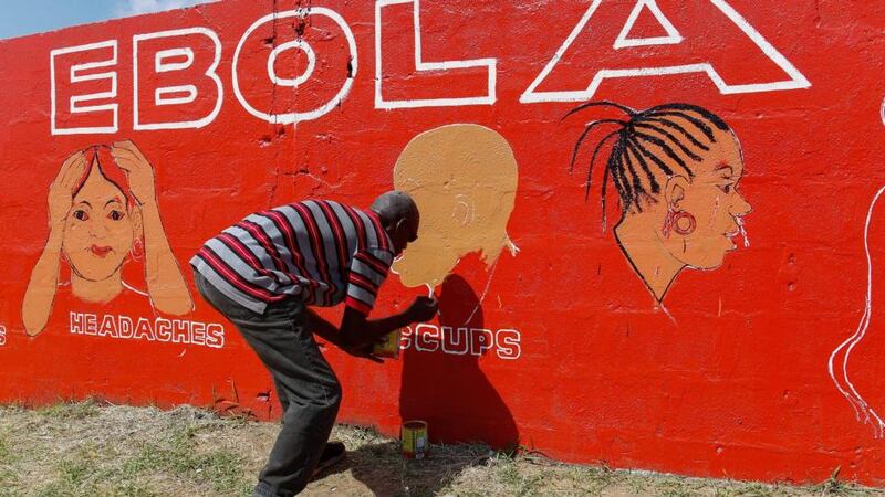 A Liberian man paints on a wall as part of an awareness programme about the deadly Ebola virus in Monrovia, Liberia. The World Health Organization (WHO) has said the number of deaths from Ebola has risen to 2100 in West Africa with an exponential surge predicted in Liberia the hardest hit country in the region. Photograph: Ahmed Jallanzo/EPA