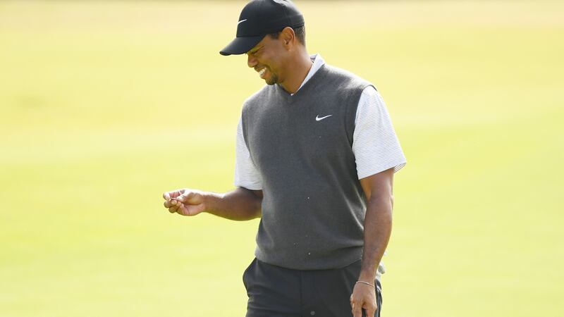 Tiger Woods smiles as he marks his ball on the 18th green during the third round of the British Open at Carnoustie. Photograph: Harry How/Getty Images