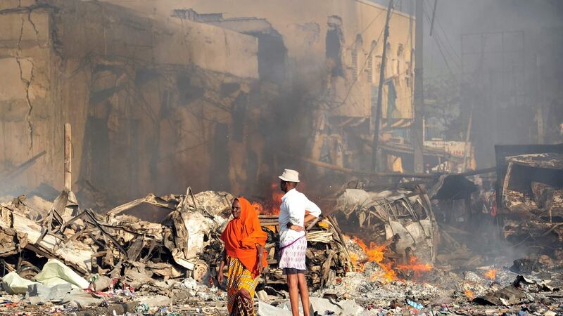 A man and woman look at the damage at the site of a truck bombing in the centre of Mogadishu, Somalia. Photograph: Mohamed Abdiwahab/AFP/Getty Images