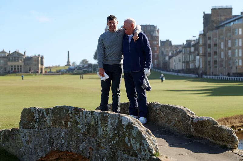 Rory McIlroy smiles alongside his father Gerry on the Swilcan Bridge. Photograph: Luke Walker/Getty