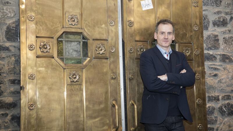 Auction organiser and antiques dealer Niall Mullen with the bronze doors from the former nightclub ’Howl at the Moon’ which sold for €12,500.