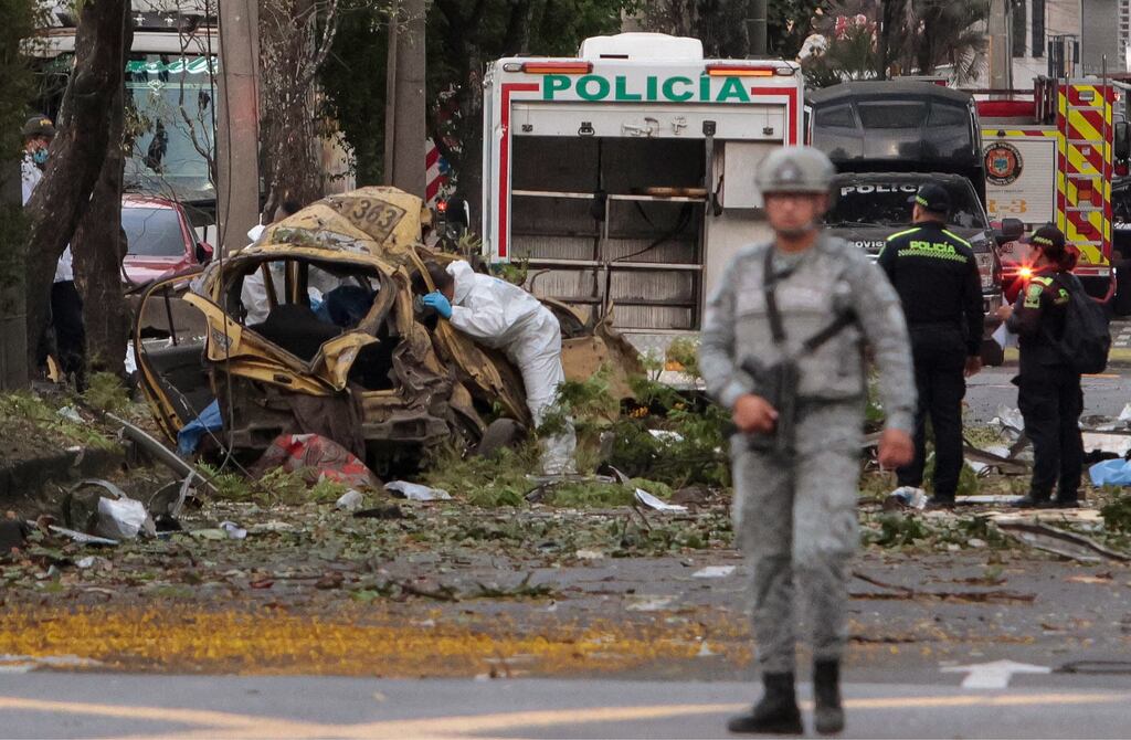 A police officer inspects the wreckage of a car on the site of a bomb explosion in cali, Colombia on August 21st. Photograph: Iusef Samir Rojas/AFP