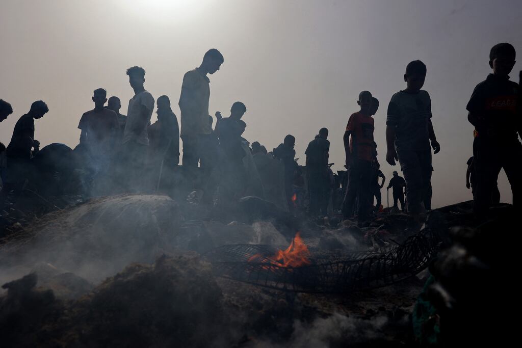 Palestinians gather at the site of an Israeli strike on a camp for internally displaced people in Rafah. Photograph: Eyad Baba/AFP via Getty Images