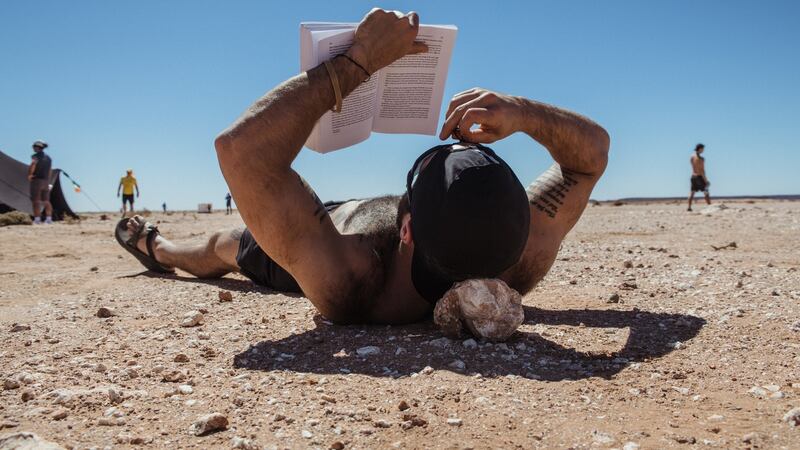 A runner uses a rock for a pillow during the Marathon des Sables.