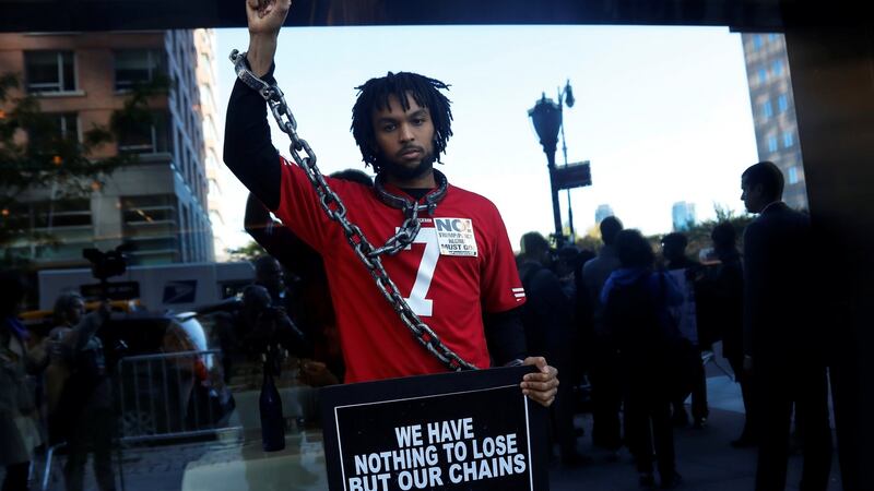 Glenn Cantave poses after a rally with other demonstrators outside the meeting. Photo: Shannon Stapleton/Reuters
