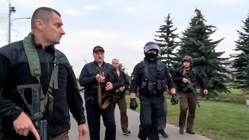 Belarusian president Alexander Lukashenko (second left), armed with a Kalashnikov-type rifle, walks surrounded by his bodyguards near the Palace of Independence in Minsk on Sunday. Photograph: State TV and Radio Company of Belarus via AP
