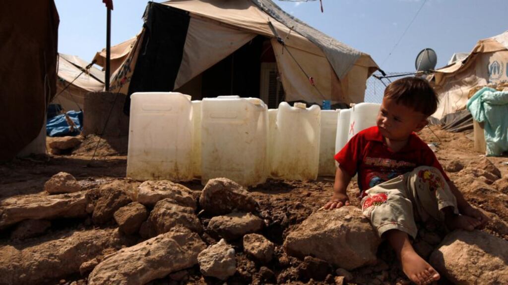 A Syrian refugee boy sits on the ground at the Domiz refugee camp in the northern Iraqi province of Dohuk. The number of Syrian children forced to flee their devastated homeland reached 1 million this week. Photograph: Thaier al-Sudani/Reuters
