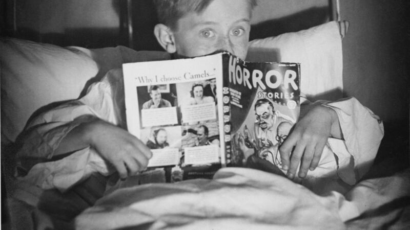 A boy in bed with a copy of Horror Stories comic book, circa 1960. Photograph: Hunter/FPG/Hulton Archive/Getty Images