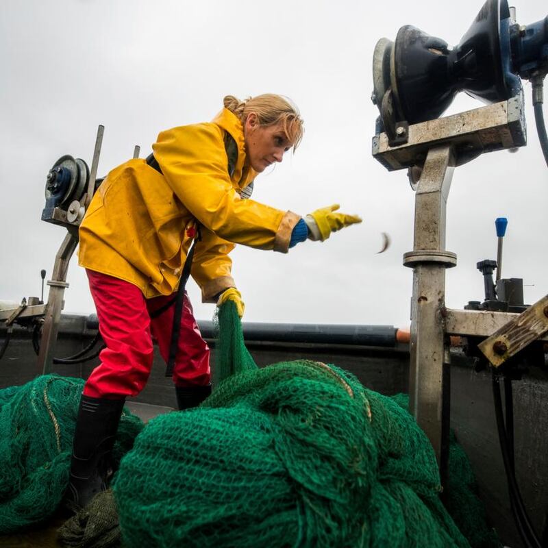 Anne Marie McStocker throws small fish back into the lough. Photograph: Liam McBurney