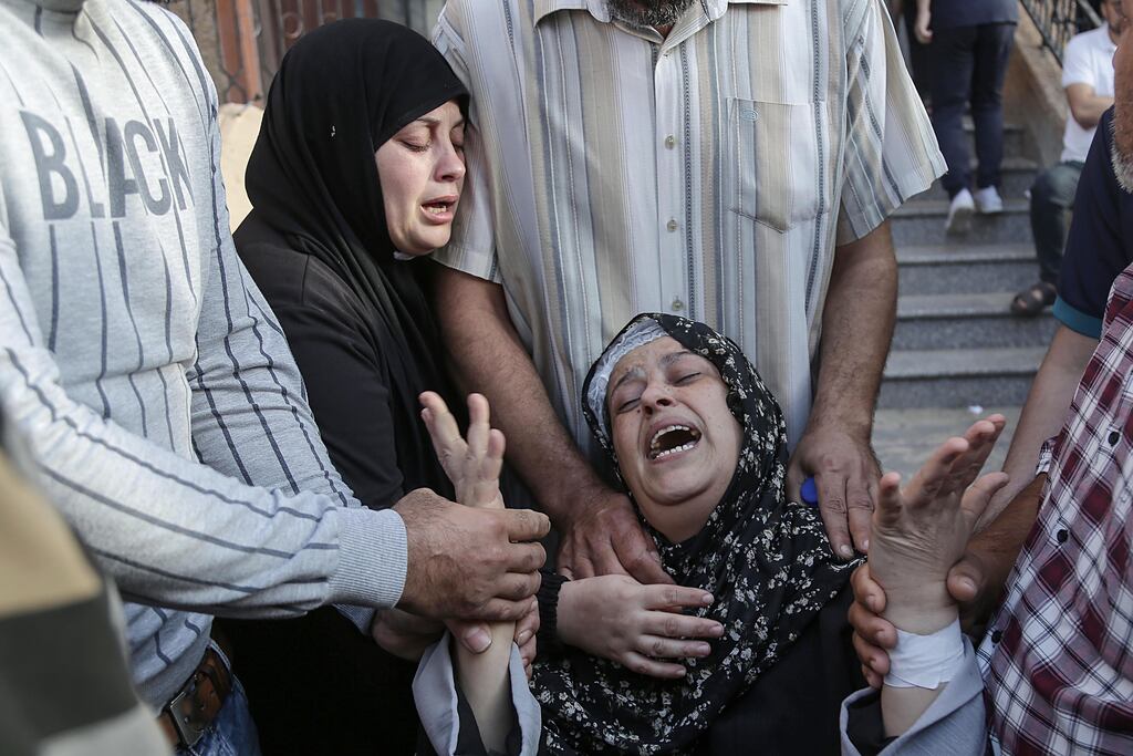 Relatives mourn over the loss of loved ones in Khan Younis, southern Gaza Strip. European leaders will meet today to discuss a potential united response to the Israel-Hamas conflict from the European Union