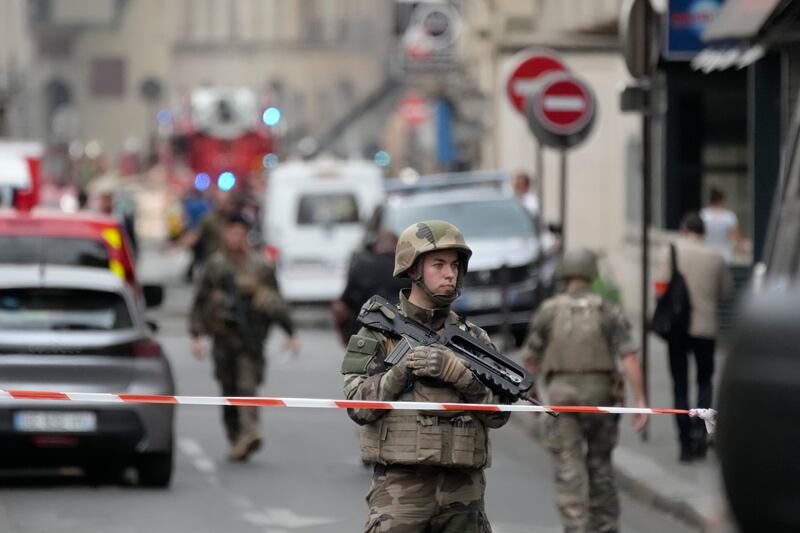 A soldier secures the area as firefighters tackle a blaze in Paris (Christophe Ena/AP)