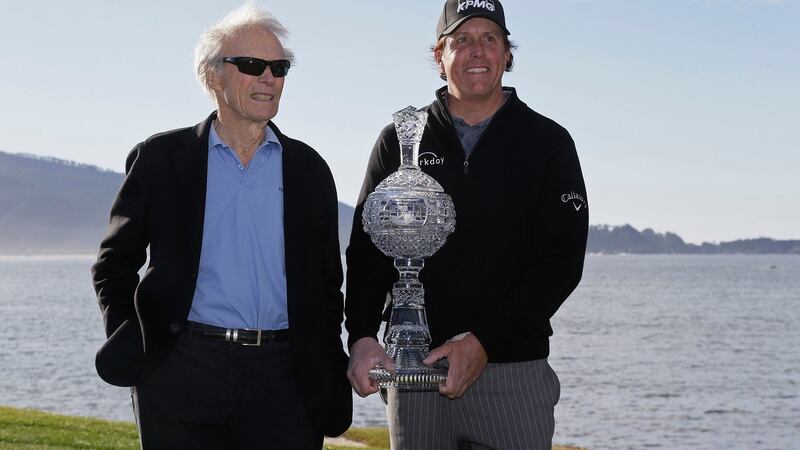 Mickelson poses with his trophy and Clint Eastwood on the 18th green. Photo: Eric Risberg/AP Photo