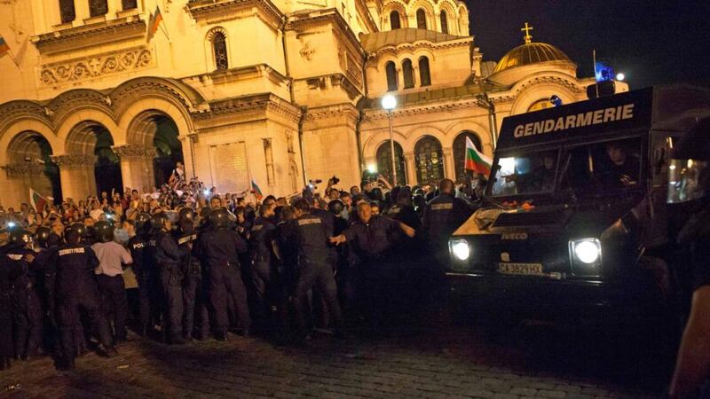Riot police officers block protesters outside the parliament building in Sofia. Photograph: Reuters