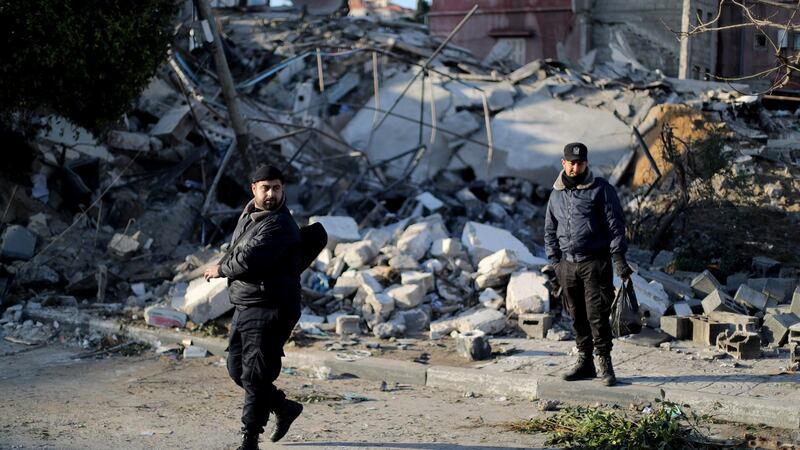 Palestinian policemen stand guard on Tuesday at the site of a Hamas-run insurance office after it was destroyed by an Israeli air strike in Gaza City. Photograph: Mohammed Salem/Reuters.