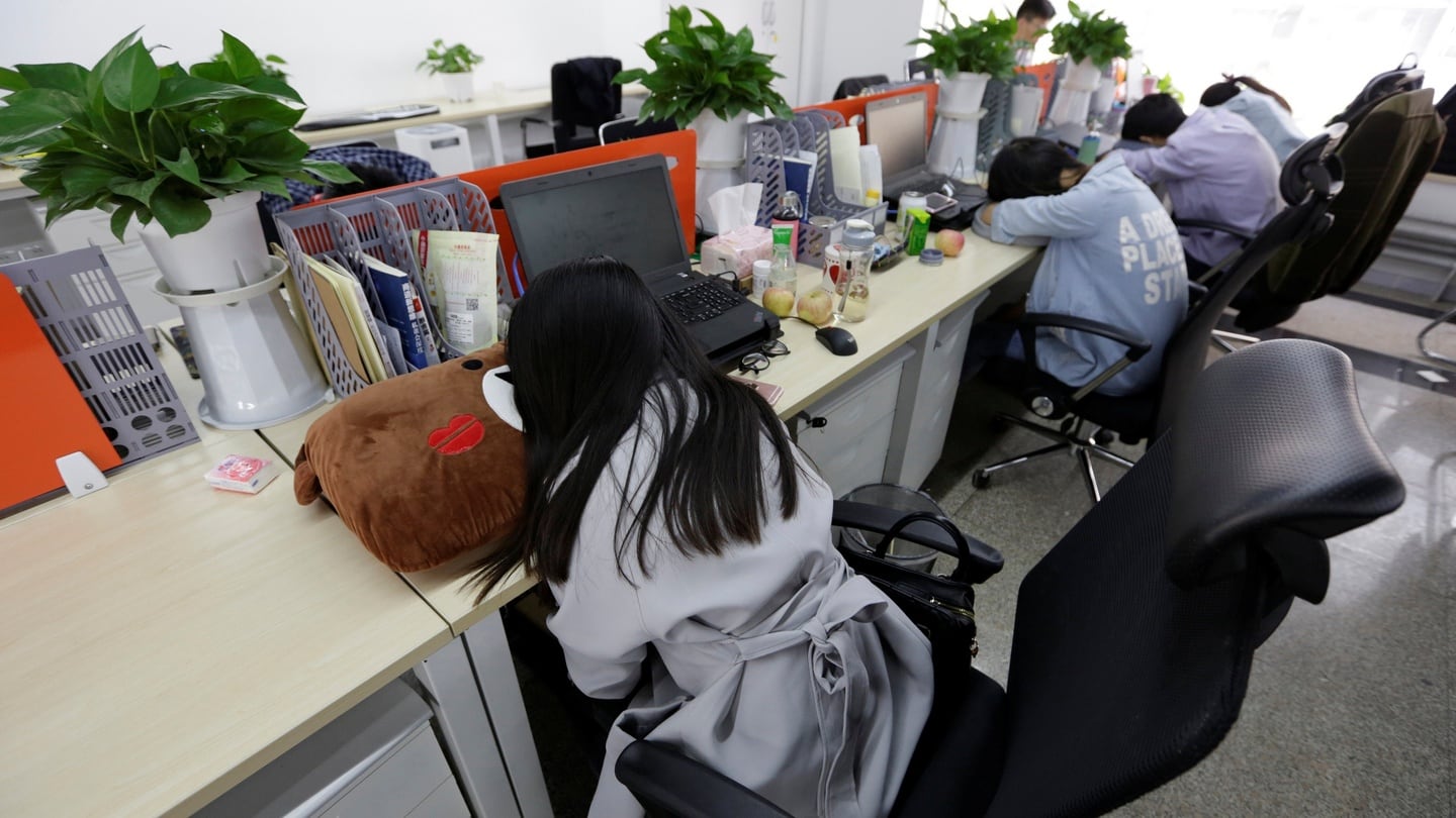 Employees at Goopal Group take a nap in their seats after lunch, in Beijing. Photograph: Jason Lee/REuters