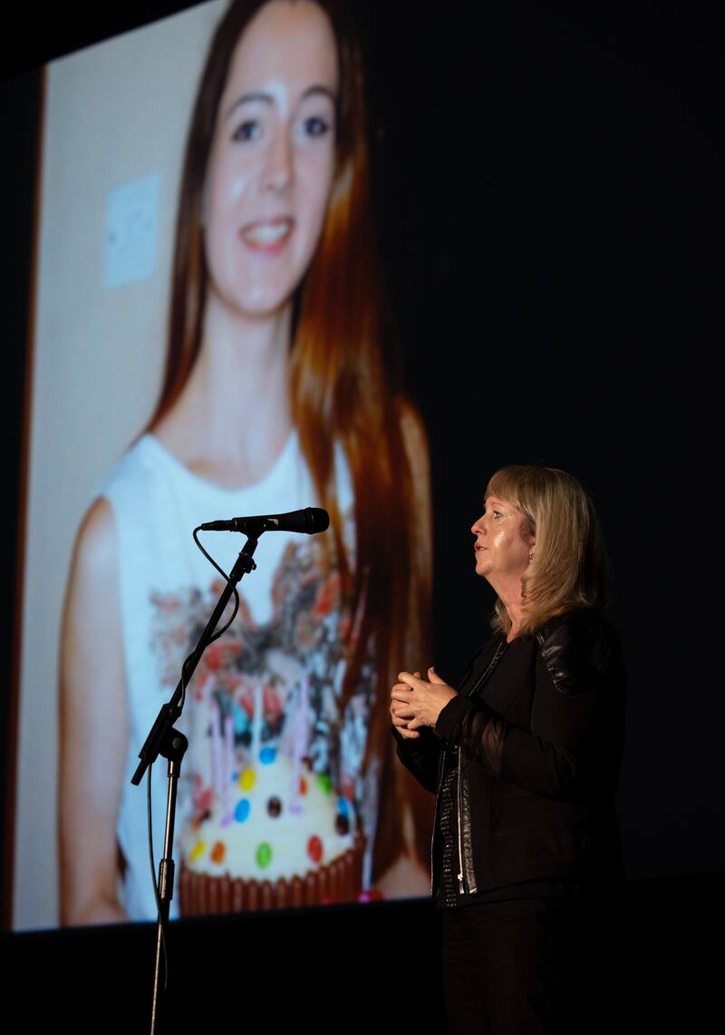 Denise Harley speaks at the event. A photograph of her late daughter Kym is displayed on the screen behind her. Kym was killed on the road days after her 19th birthday. Photograph: Joe Dunne