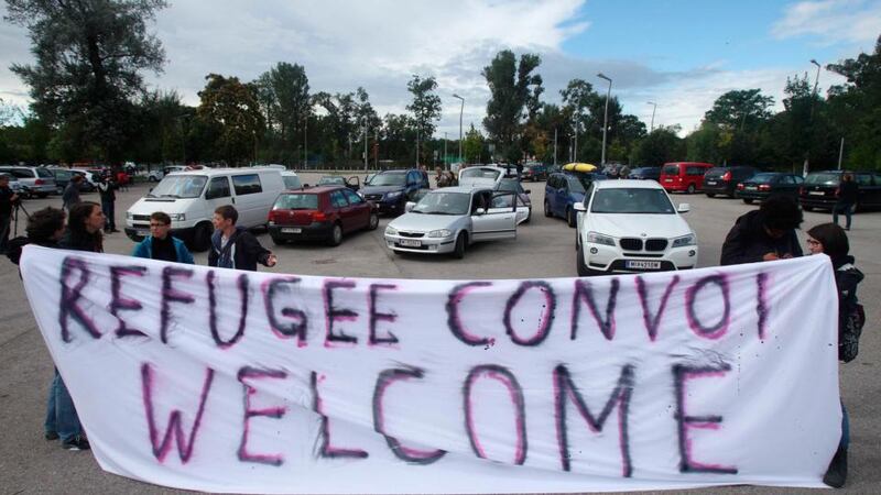 Activists hold a banner at a parking lot in Vienna before a convoy of around 140 cars leaves for Hungary to distribute aid and collect refugees to bring back to Austria. Photograph: Heinz-Peter Bader/Reuters