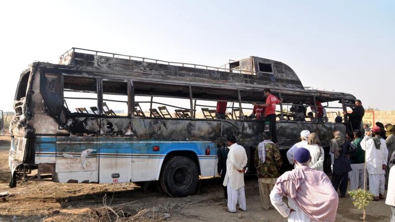 The wreckage of a bus after it collided with an oil tanker and burst into flames, near Karachi. Photograph: EPA