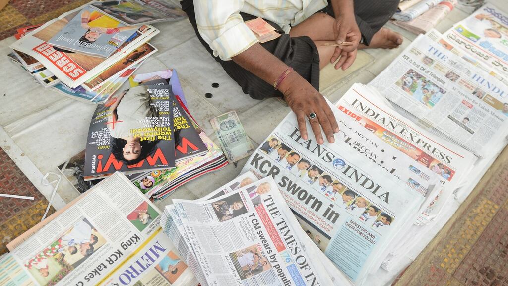 A newspaper salesman in India organises his stock. Photograph: Noah Seelam/AFP/Getty Images