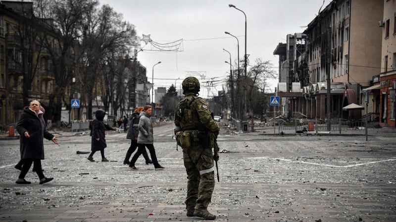 People pass by a Russian soldier in central Mariupol Photograph: Alexander Nemenov/AFP via Getty