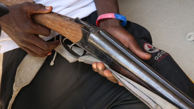 A Civilian Joint Task Force  member shows off a rifle  captured from Boko Haram.