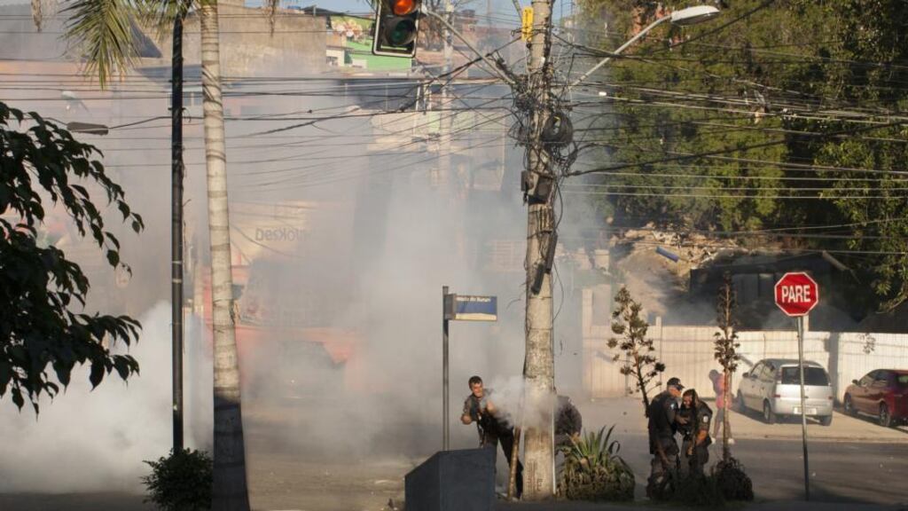 Riot policemen fire tear gas against residents of the Complexo Alemao during protests calling attention to the violence that erupts during police operations against suspected drug traffickers in the Rio de Janeiro slum in early April. The slum has once again experienced violent clashes with police following the death of Eduardo de Jesus Ferreira (10). Photograph: Rafael Fabres/AFP/Getty Images