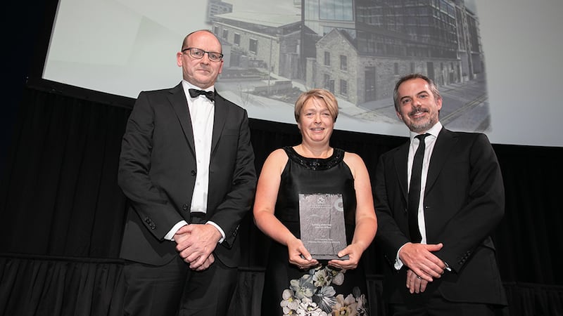 Susan Cormican, Director Urbanism, Ethos Engineering, presents the Building of the Year – Medium Office award to Conor Kinsella, O'Mahony Pike Architects & Ben Thomas, MOLA Architecture.