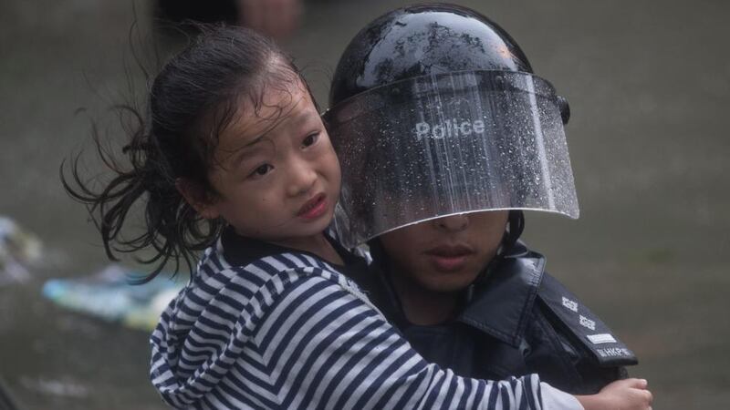 A police officer rescues a child from a flooded street during Typhoon Mangkhut in Lei Yu Mun, Hong Kong. Photograph: Jerome Favre/EPA