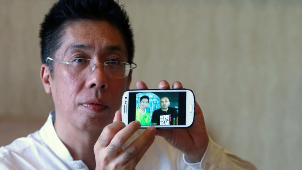 Peter Chong holds up a photograph of him with missing Malaysia Airlines Flight MH370 captain Zaharie Ahmad Shah during an interview. Photograph: Samsul Said/Reuters