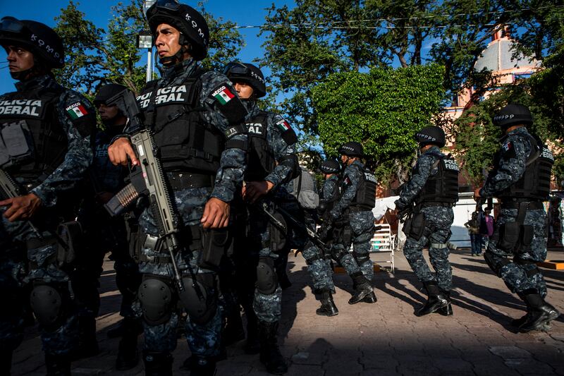 Members of the Mexican army and the federal police arrive in Iguala, Mexico, in October 2014. In August 2022, the government unveiled a truth commission report saying that after being abducted in southern Mexico in 2014, 43 missing students were killed by drug traffickers working with the police and the military. Photograph: Adriana Zehbrauskas/The New York Times
