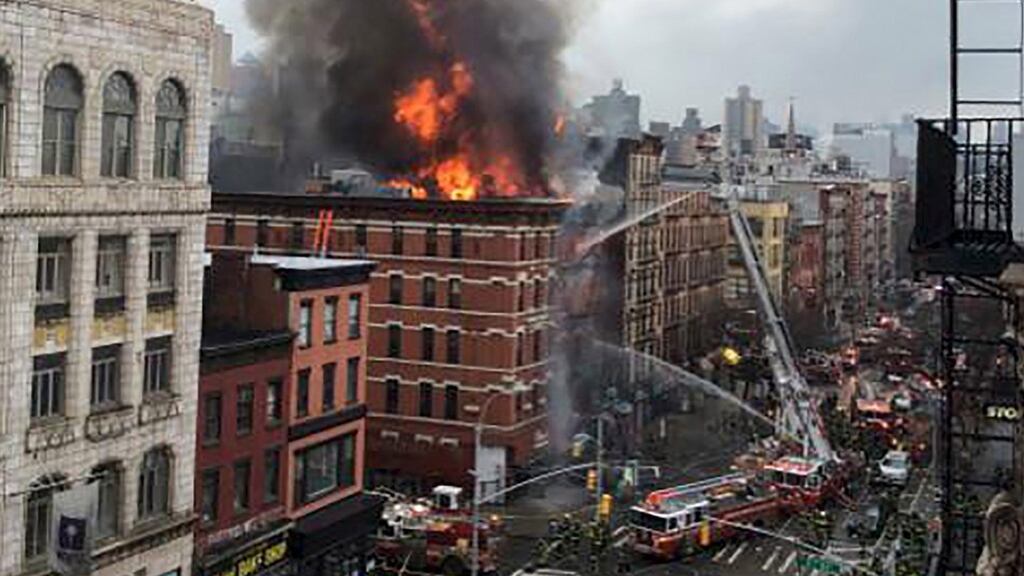 Fire shoots from the roof of a building after it collapsed and burst into flames in New York City’s East Village. Photograph: Scott Westerfeld/Reuters