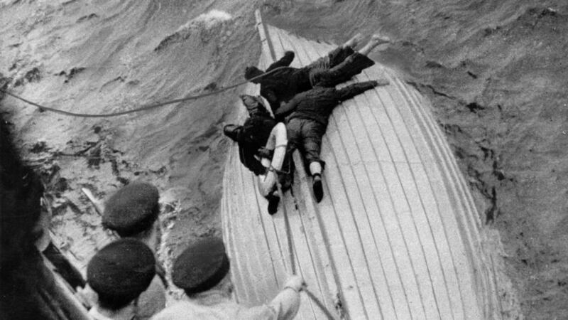 War at sea: merchant sailors cling to a lifeboat during the second World War as a French cruiser arrives to rescue them. Photograph: Central Press/Getty